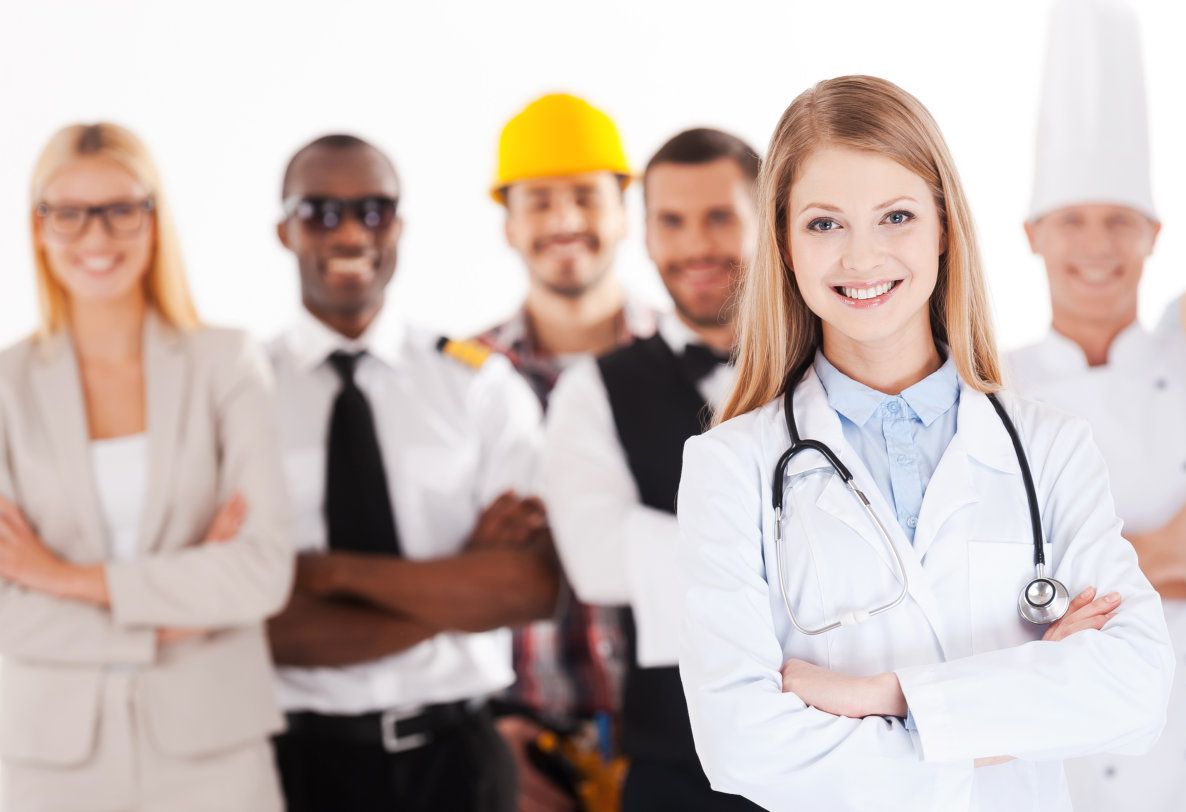 a young, smiling female doctor standing in the foreground with her arms crossed